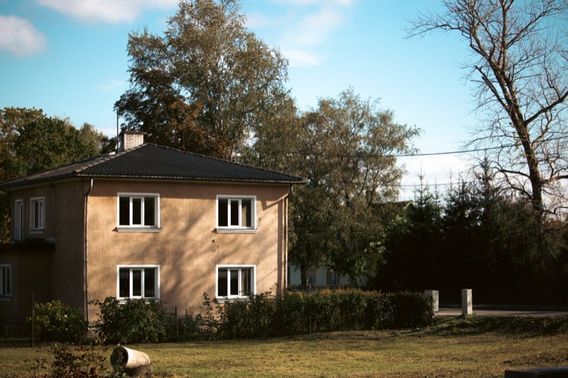 A picturesque view of a traditional house surrounded by autumn foliage in Tartu, Estonia.