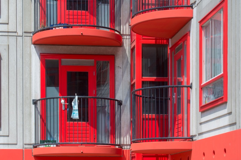 Vibrant red balconies with unique design on a modern residential building facade