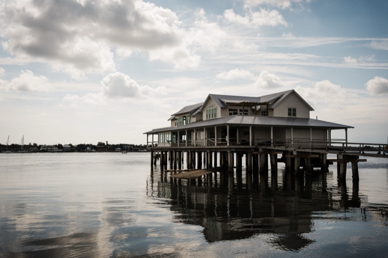 Charming waterfront house on stilts in St. Augustine, Florida under a partly cloudy sky.