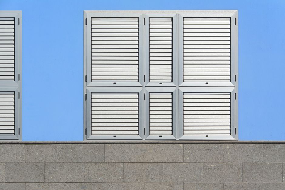 Clean and simple design of a blue wall featuring aluminum shutters, ideal for architectural themes.
