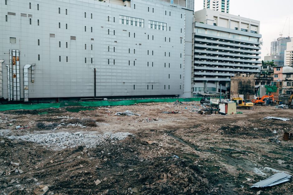 A construction site with surrounding modern buildings in an urban setting.