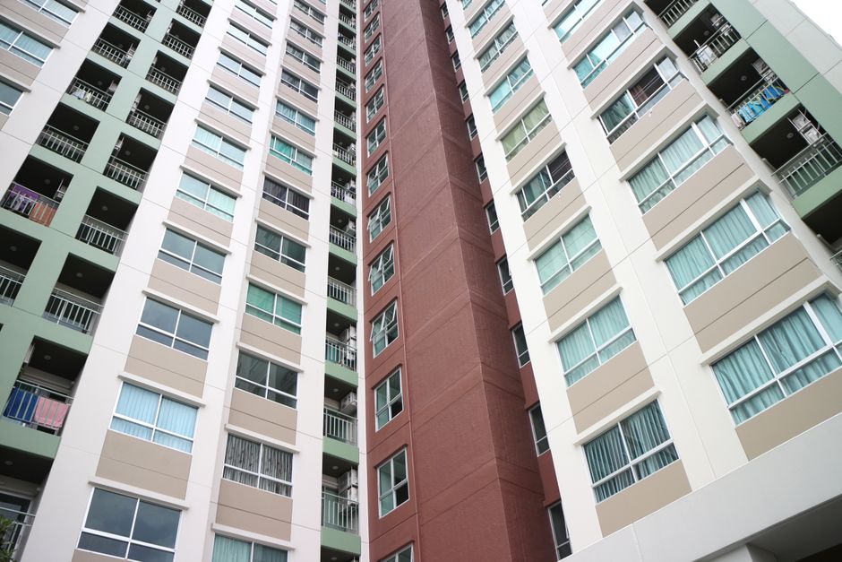 Low-angle view of a modern apartment complex in Bangkok with diverse facade colors.