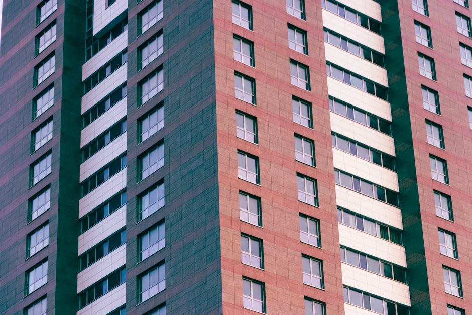 Close-up of a modern high-rise building with glass windows and geometric patterns.