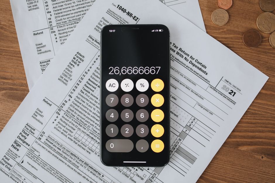 Mobile calculator app on tax documents, highlighting financial calculations and tax preparation.
