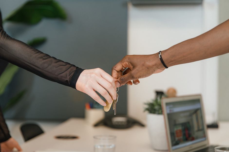 Professional office setting showing a key exchange symbolizing a business deal or real estate transaction.